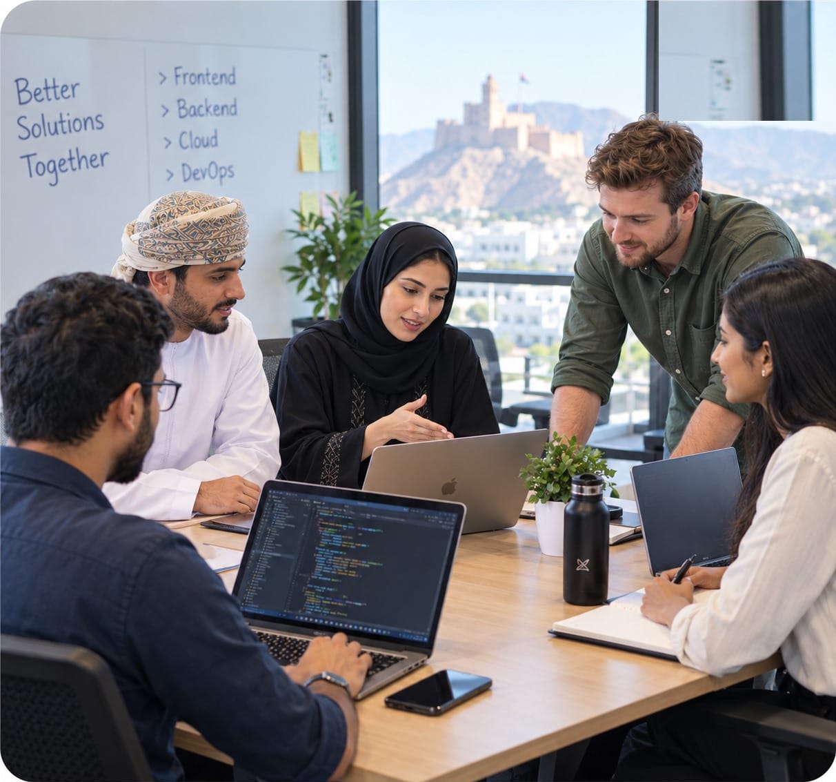 A technology team collaborating around a laptop during a project planning session